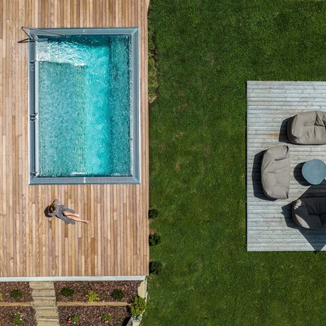 Hotel Schmung: our picture gallery Aerial view of pool with wooden deck and seating area on green lawn
