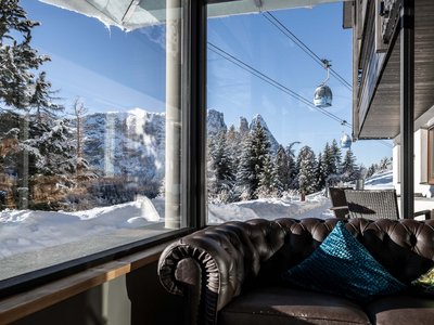 Hotel Schmung: holidays in harmony with nature View from window of snowy mountains and cable cars with sofa in foreground
