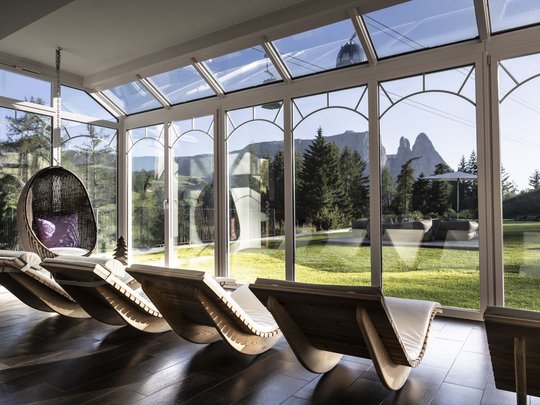 Hotel Schmung: una vacanza a contatto con la natura Lettini moderni e sedia sospesa davanti a grandi finestre con vista sulle montagne