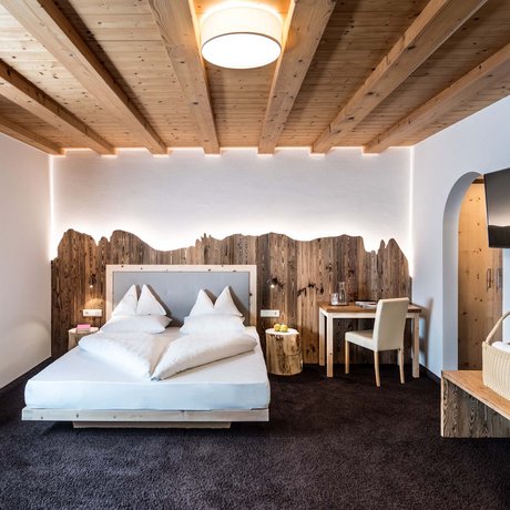 Hotel Schmung: our picture gallery Cozy bedroom with wooden ceiling and mountain-themed wood decoration