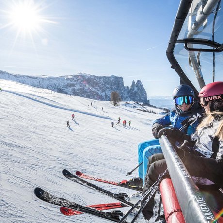 Hotel Schmung: our picture gallery Two skiers on a chairlift with snowy mountain landscape in the background