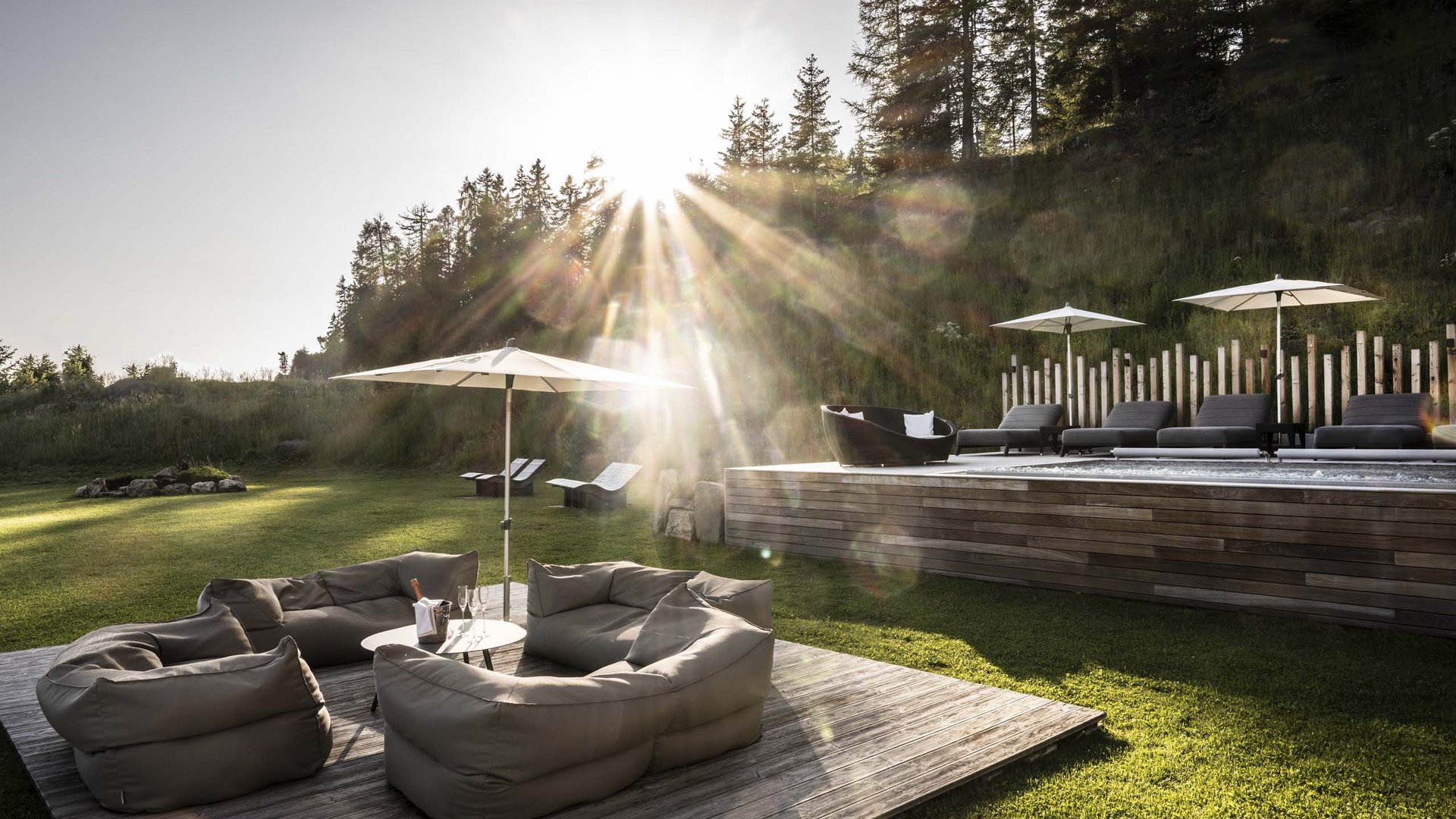 Hotel Schmung: wellness at Alpe di Siusi/Seiser Alm Sunset over modern lounge with bean bags and pool in garden