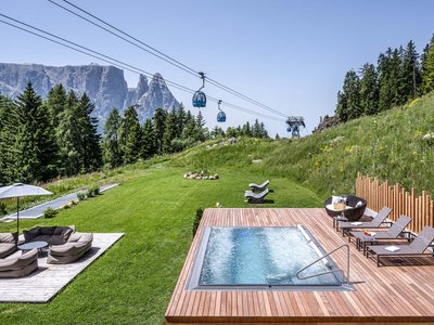 Hotel Schmung: wellness at Alpe di Siusi/Seiser Alm Hot tub on wooden deck with cable cars and mountains in the background