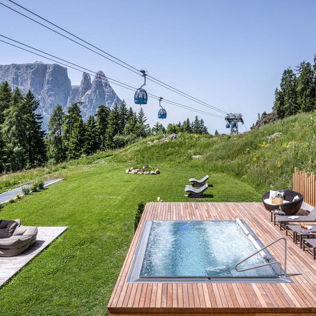 Hotel Schmung: our picture gallery Hot tub on wooden deck with cable cars and mountains in the background