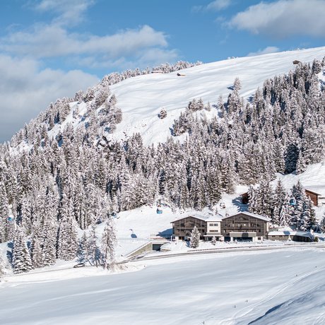 Hotel Schmung: our picture gallery Snow-covered chalet and forest on a sunny winter mountain