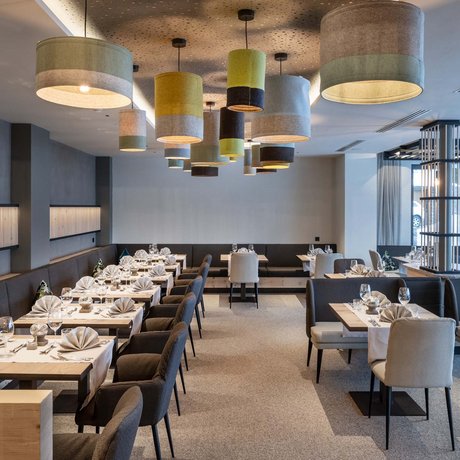 Hotel Schmung: our picture gallery Modern restaurant with elegant tables, chairs, and decorative hanging lamps