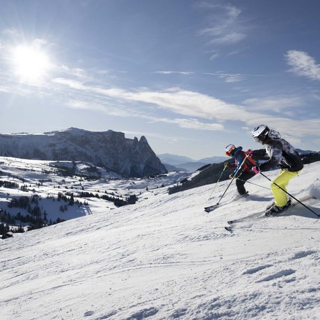 Hotel Schmung: our picture gallery Two skiers on snowy slope with sunny mountains in the background