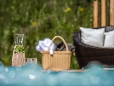 Hotel Schmung: wellness at Alpe di Siusi/Seiser Alm Carafe with mint water beside basket and lounge chair near pool
