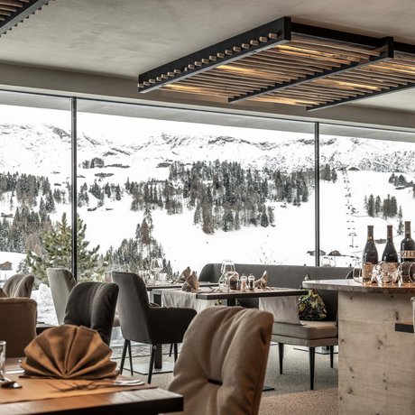 Hotel Schmung: our picture gallery Cozy restaurant with view of snowy mountains and pine trees