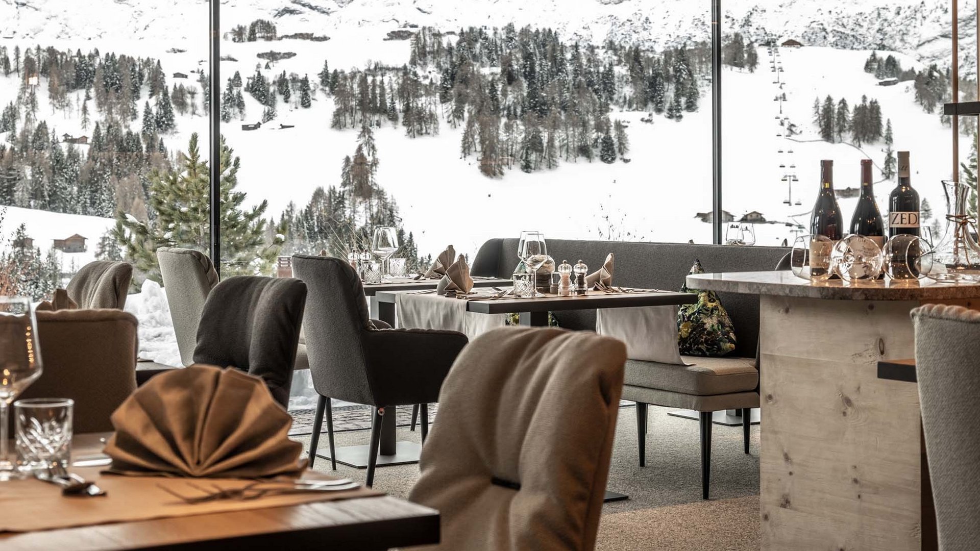 Cozy restaurant with view of snowy mountains and pine trees