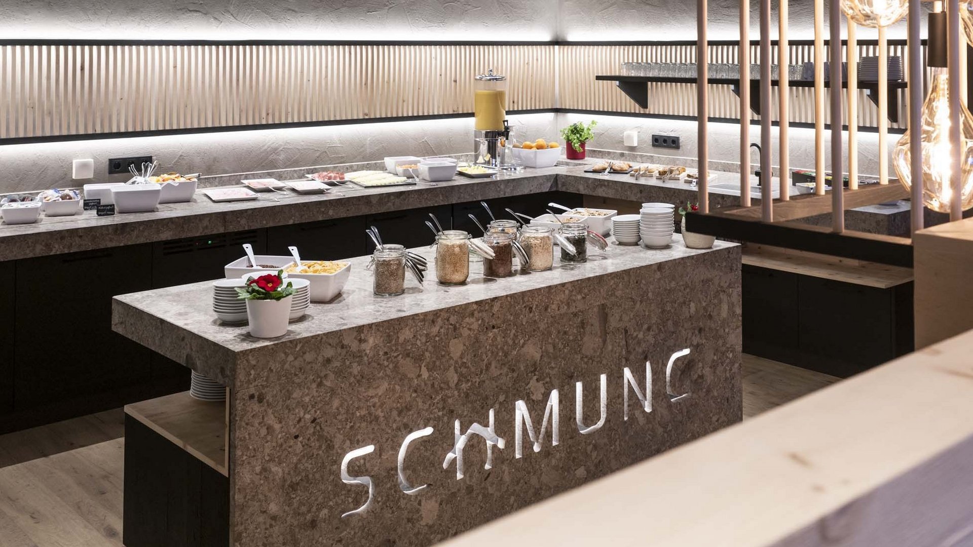 Modernes, beleuchtetes Frühstücksbuffet im Hotel mit diversen Speisen
