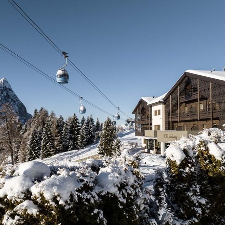 Hotel Schmung: our picture gallery Snow-covered hotel in the mountains with gondola lift and clear sky