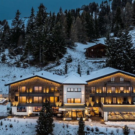 Hotel Schmung: our picture gallery Lit hotel in snowy mountain landscape with pine trees at night