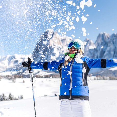 Hotel Schmung: our picture gallery Woman throwing snow in ski gear with mountains in the background