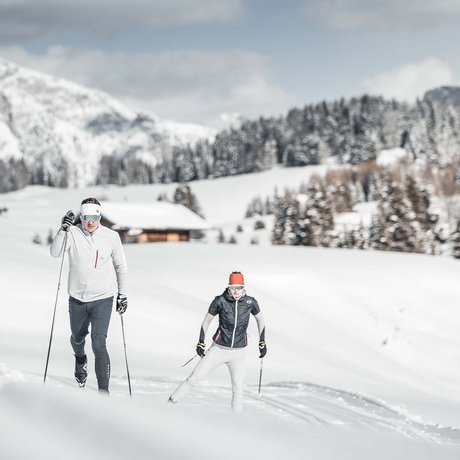 Hotel Schmung: our picture gallery Two people cross-country skiing in snowy mountain landscape with pine trees