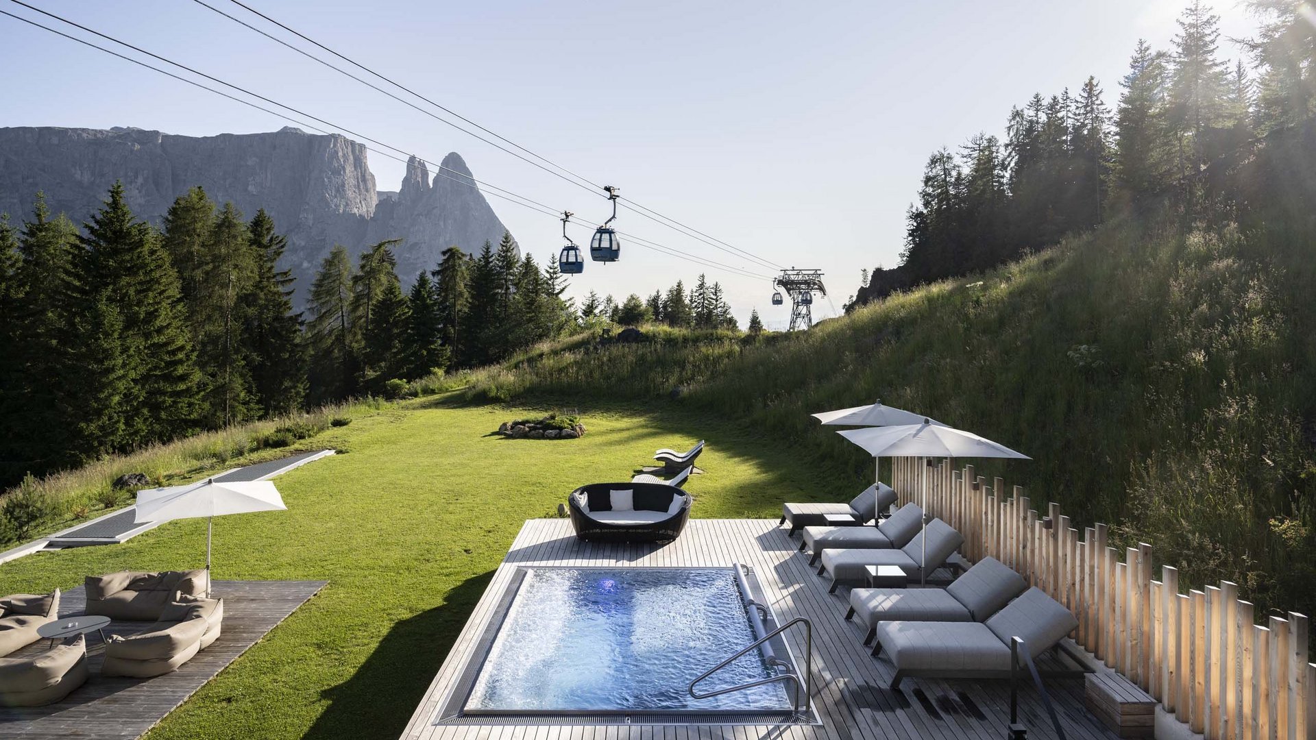 Hotel Schmung: wellness at Alpe di Siusi/Seiser Alm Hot tub and loungers with mountain view and cable cars in summer