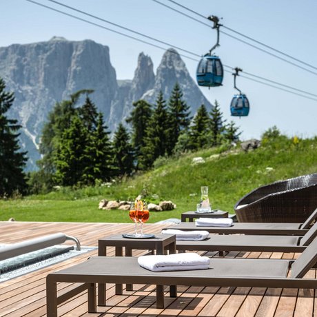 Hotel Schmung: our picture gallery Pool terrace with loungers, drinks, and mountain view with cable cars