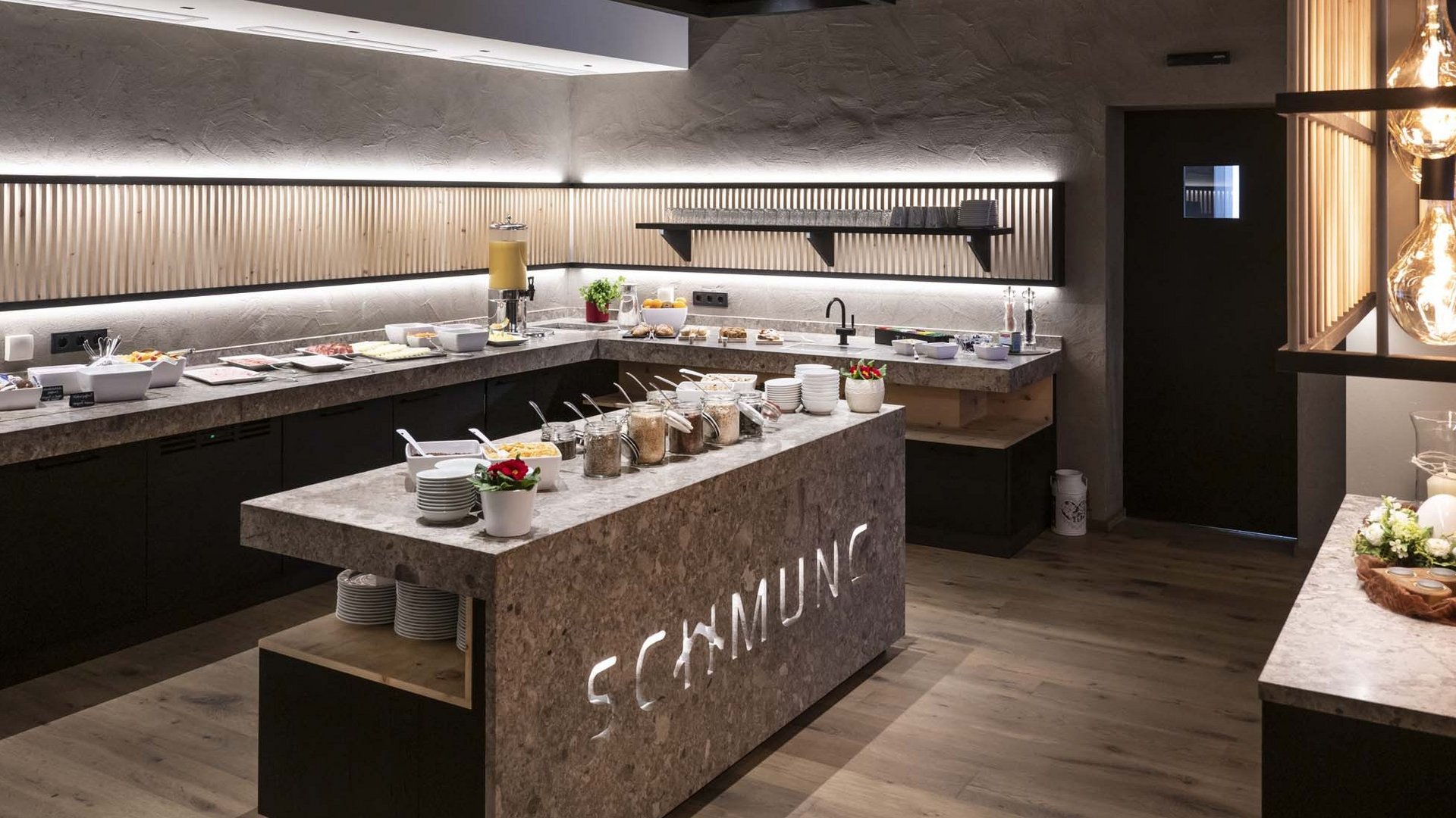 Culinary highlights at Hotel Schmung Modern buffet with stylish lighting and various breakfast items